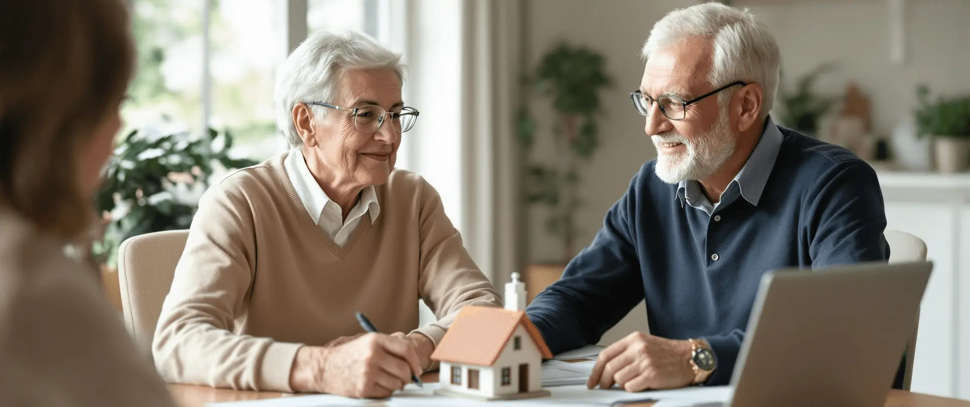 Senior couple meeting with an advisor to review home ownership and estate documents in a bright, professional setting.