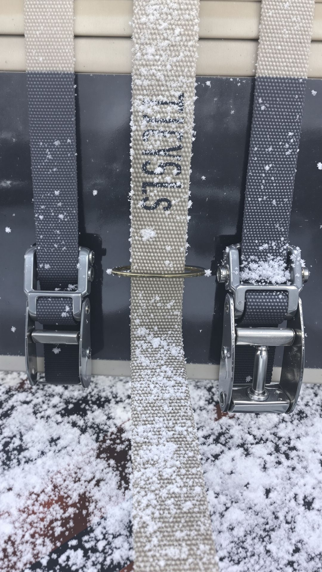 Winter-stiffened ratchet straps securing kitchen countertop–grade slabs on a flatbed, with frost crystals visible on straps and hardware. Winter-stiffened ratchet straps securing kitchen countertop–grade slabs on a flatbed, with frost crystals visible on straps and hardware.