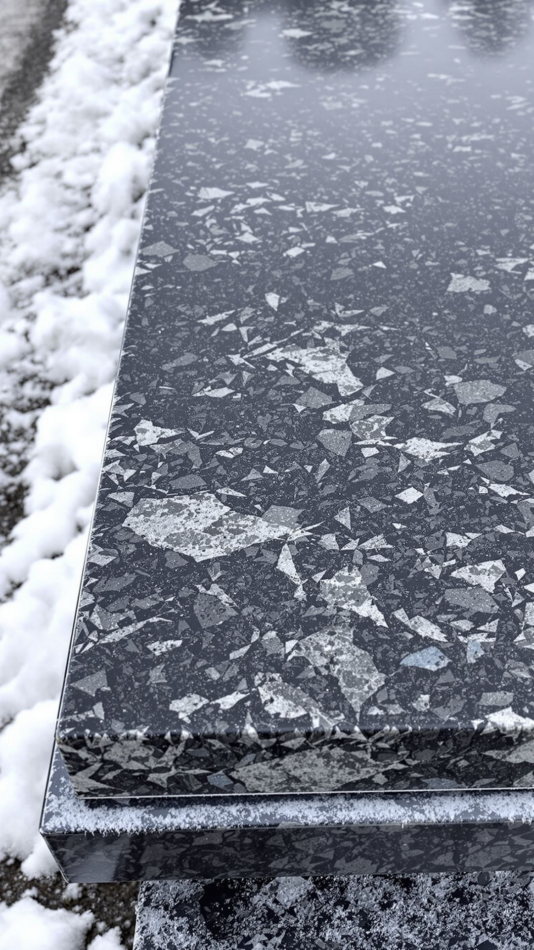 Close-up of a granite or quartz countertop slab on a flatbed in winter, showing frost on metal edges and subtle road vibration effects. Close-up of a granite or quartz countertop slab on a flatbed in winter, showing frost on metal edges and subtle road vibration effects.
